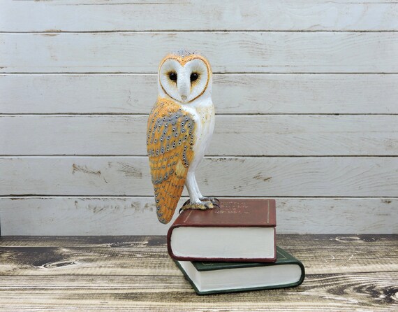 Barn owl on books, an owl sculpture.