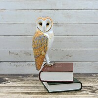 Barn owl on books, an owl sculpture.