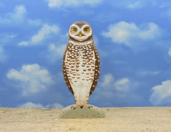 An owl sculpture, a burrowing owl, a wooden owl.
